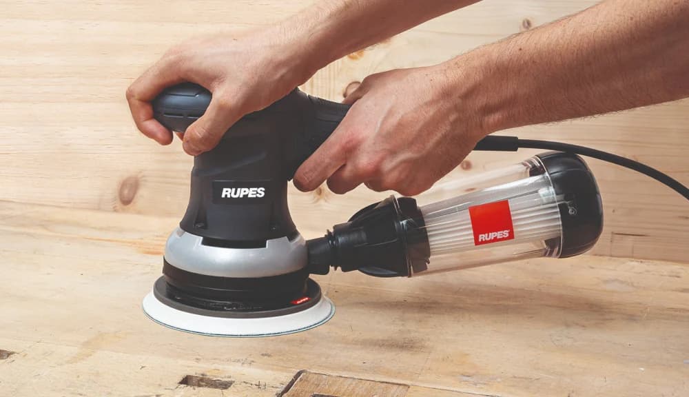 Een schuurmachine van Rupes die een houten oppervlak schuurt